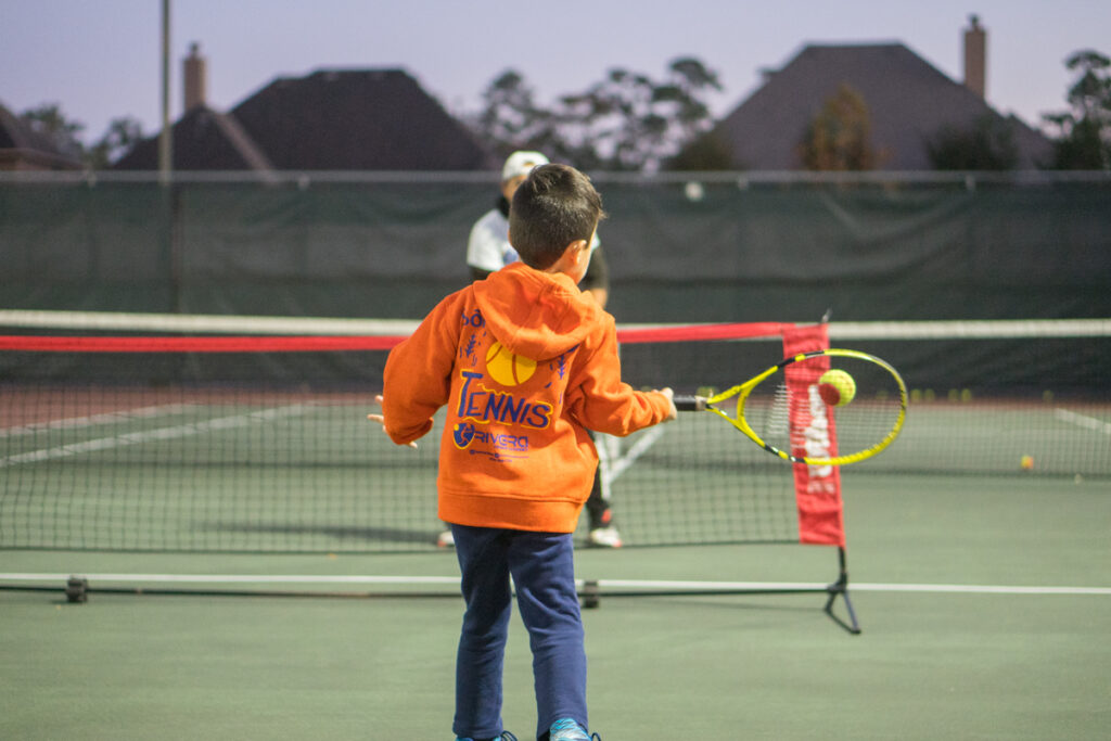 Kids Tennis Lessons - a boy holding hitting a forehand Kids Tennis Lessons - a boy holding hitting a forehand